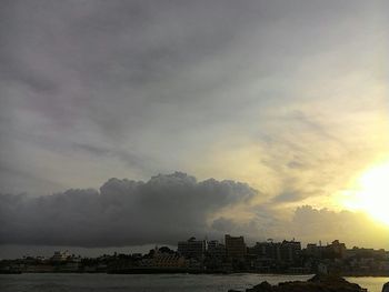 View of cityscape against cloudy sky at sunset