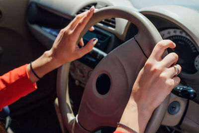 A young woman is sitting at the wheel of a car.hands on the steering wheel close-up.