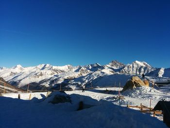 Scenic view of snowcapped mountains against clear blue sky