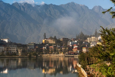 Panoramic view of townscape by mountains against sky