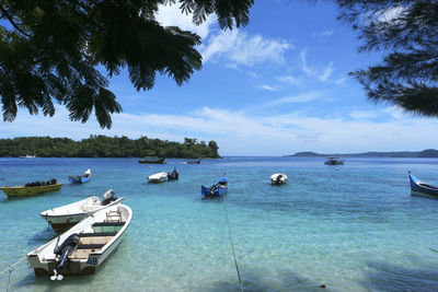 Boats moored in sea against sky