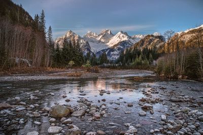 Scenic view of lake by mountains against sky