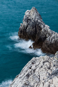 Rock formations by sea against blue sky