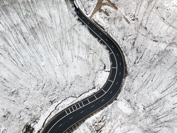 Winding road through the forest, from high mountain pass, in winter time