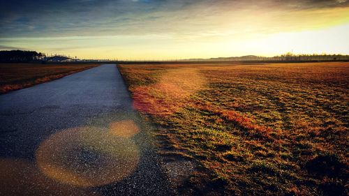 Scenic view of field against sky at sunset