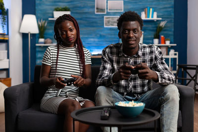 Young man and woman playing video game at home