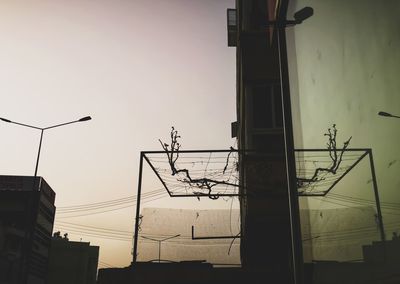 Low angle view of silhouette electricity pylon against sky