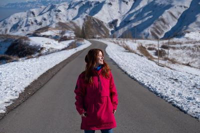 Rear view of woman walking on road