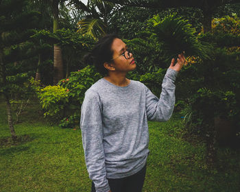 Teenage girl standing against plants