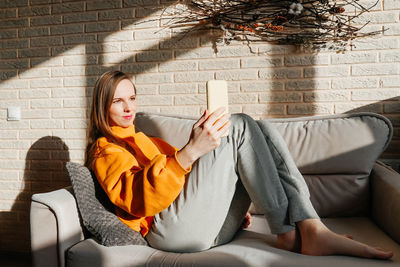 Young woman sitting on sofa