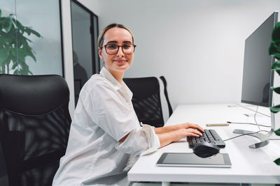 Portrait of young businesswoman working at desk in office