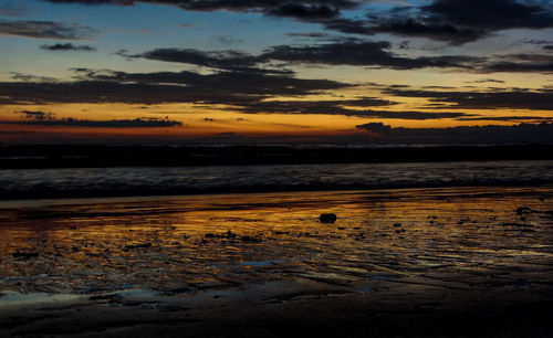 Scenic view of beach against sky during sunset