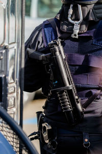 Midsection of police officer with gun