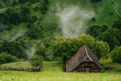 Scenic view of cottage on mountain meadow in summer