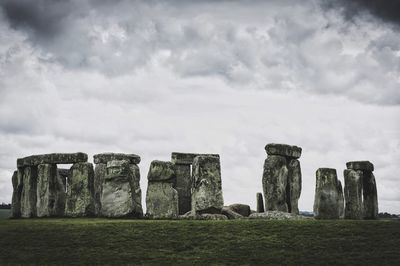 Old ruins on field against cloudy sky