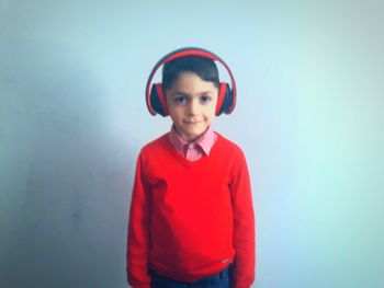 Portrait of boy standing against blue sky