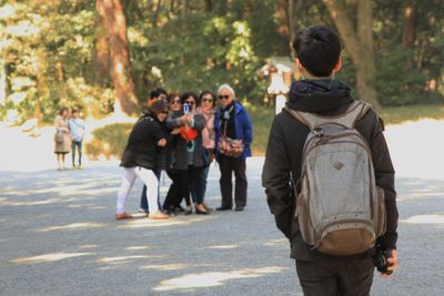 Rear view of people walking on road