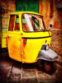 Close-up of yellow car on street