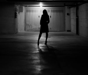 Full length of silhouette woman standing in corridor of building