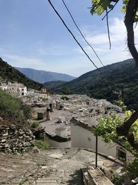 Scenic view of buildings and mountains against sky