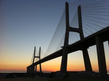 Low angle view of suspension bridge at sunset