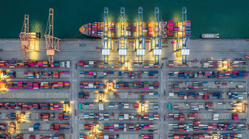 Aerial view container ship working at night terminal dock seaport, global business company.