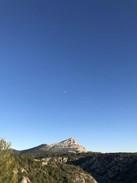 Scenic view of mountains against clear blue sky