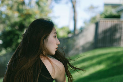 Rear view of woman looking away while standing at park