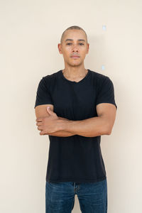 Portrait of young man standing against white background