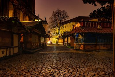 Street amidst buildings at night