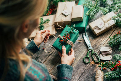 Unrecognizable woman decorating christmas gifts