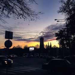 Cars on road against sky during sunset