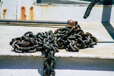 Close-up of rusty chain tied up on metal