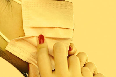 Close-up of hand holding tea cup against gray background