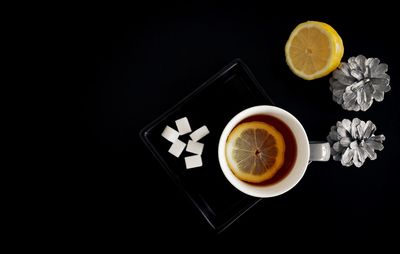 Directly above shot of tea on table against black background