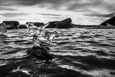 Surface level of rocks in sea against sky