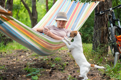 Side view of woman with dog on field