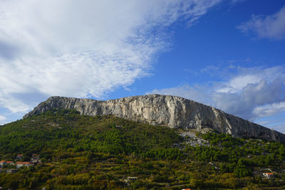 Low angle view of rocky mountain against sky