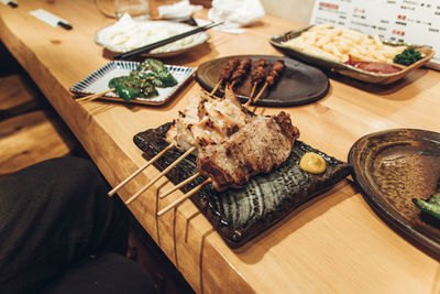 High angle view of yakitori and yakiton  served on table at izakaya restaurant in japan