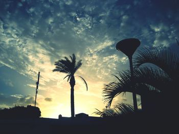 Silhouette of trees against cloudy sky