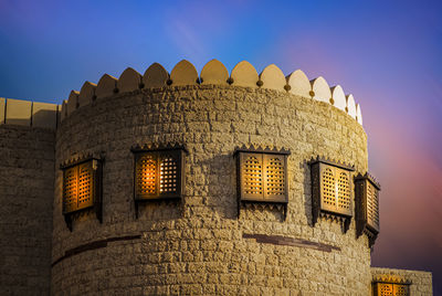 Low angle view of illuminated building against sky