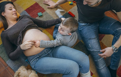 High angle view parents and son playing with toys at home