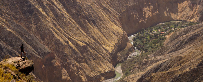 Man standing on cliff over valley