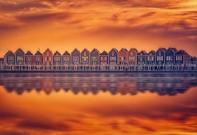 Building by sea against orange sky