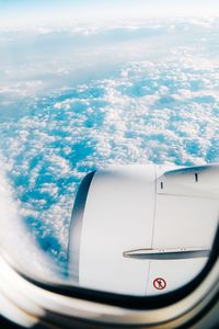 Close-up of airplane wing over sea against sky