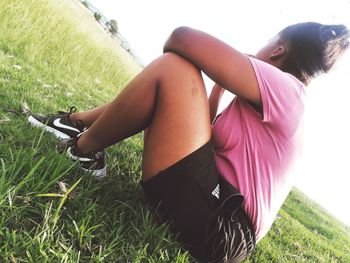 Midsection of woman relaxing on field