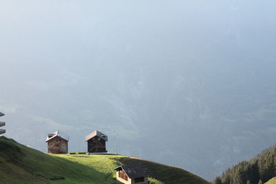 Scenic view of two swiss wooden chalets facing the valley in mountains.