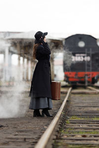 Rear view of man walking on railroad track