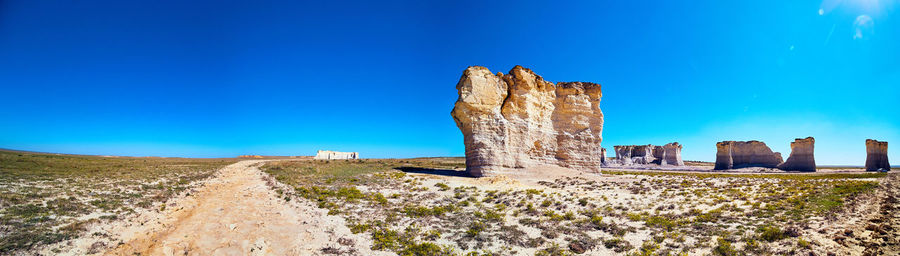 Castle on rock formations against clear blue sky