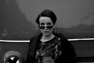 Portrait of young woman wearing sunglasses standing outdoors